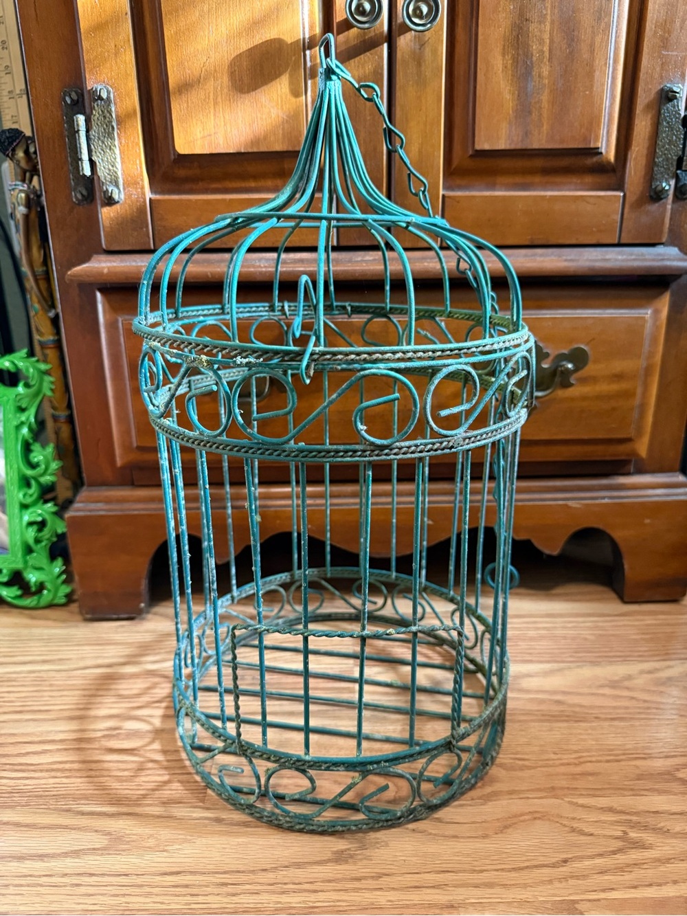 Green rustic decorative garden birdcage for plants or decor.